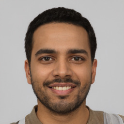 Joyful latino young-adult male with short  black hair and brown eyes