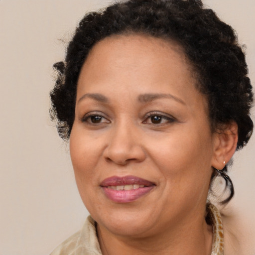 Joyful black adult female with medium  brown hair and brown eyes