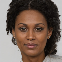 Joyful black adult female with medium  brown hair and brown eyes