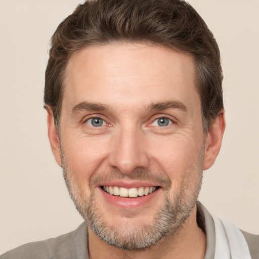 Joyful white adult male with short  brown hair and brown eyes