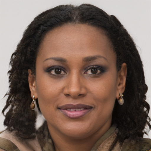 Joyful black young-adult female with long  brown hair and brown eyes