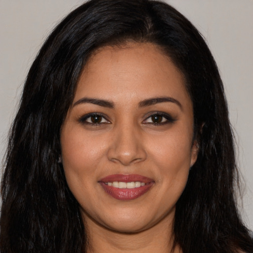 Joyful latino young-adult female with long  brown hair and brown eyes