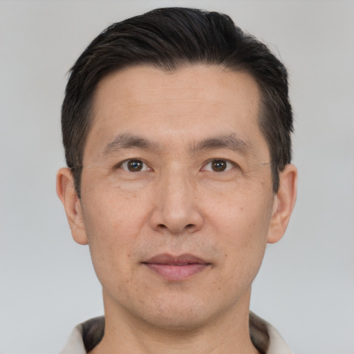 Joyful asian adult male with short  brown hair and brown eyes