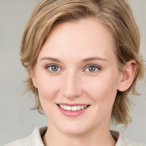 Joyful white young-adult female with medium  brown hair and blue eyes