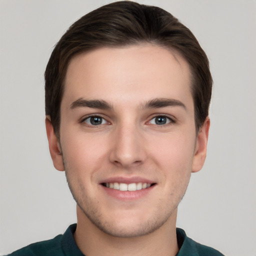 Joyful white young-adult male with short  brown hair and grey eyes