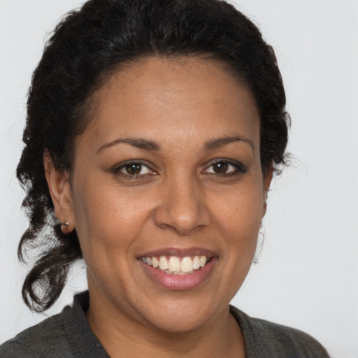 Joyful latino adult female with medium  brown hair and brown eyes