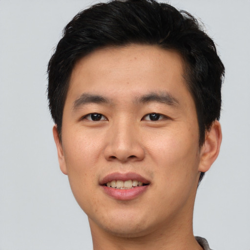 Joyful asian young-adult male with short  brown hair and brown eyes