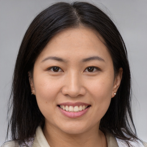 Joyful asian young-adult female with medium  brown hair and brown eyes