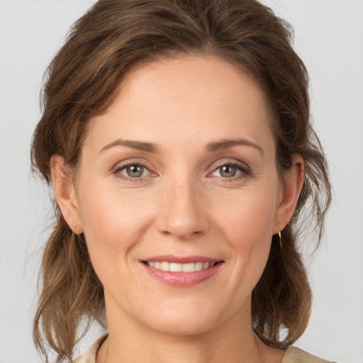 Joyful white young-adult female with medium  brown hair and grey eyes