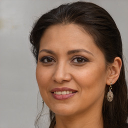 Joyful white adult female with long  brown hair and brown eyes