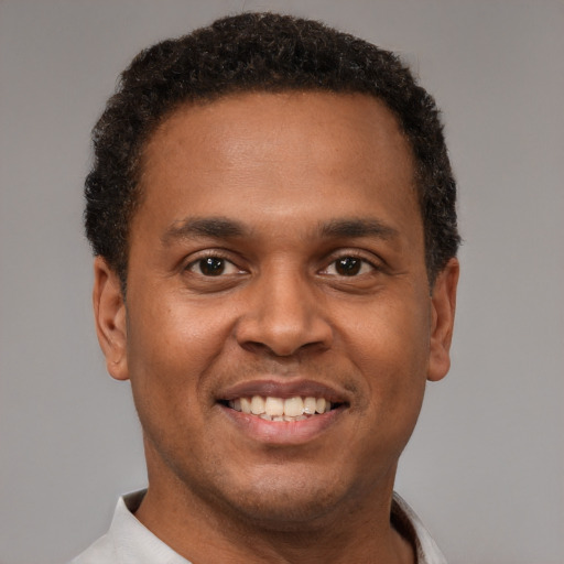 Joyful latino young-adult male with short  brown hair and brown eyes