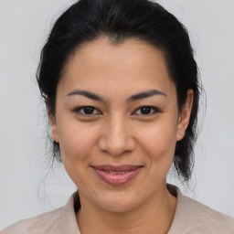 Joyful latino young-adult female with medium  brown hair and brown eyes