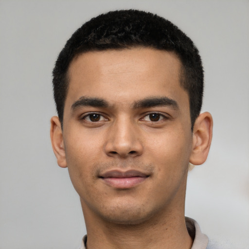 Joyful latino young-adult male with short  black hair and brown eyes