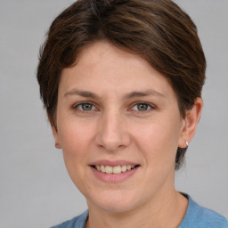 Joyful white young-adult female with medium  brown hair and grey eyes