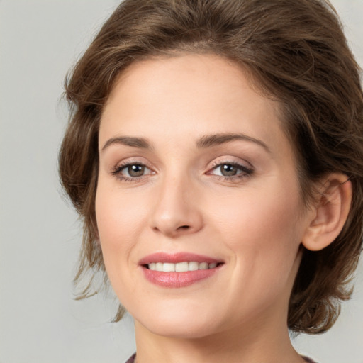 Joyful white young-adult female with medium  brown hair and green eyes