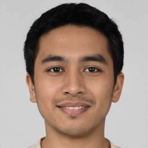 Joyful latino young-adult male with short  black hair and brown eyes