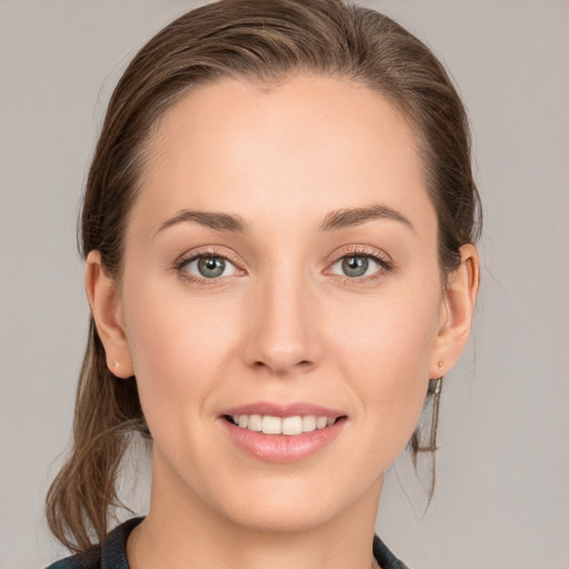 Joyful white young-adult female with medium  brown hair and grey eyes