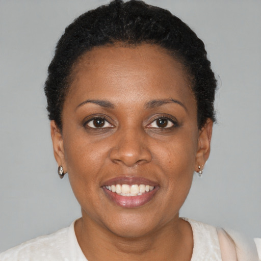 Joyful black young-adult female with short  brown hair and brown eyes