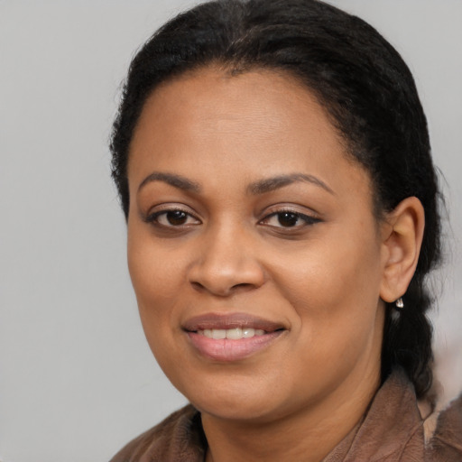 Joyful black young-adult female with long  black hair and brown eyes