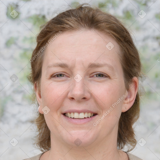 Joyful white adult female with medium  brown hair and blue eyes