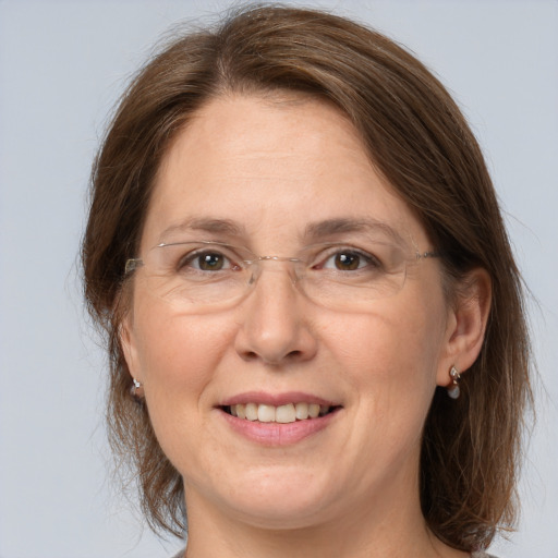 Joyful white adult female with medium  brown hair and grey eyes