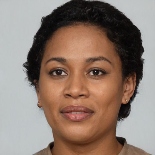 Joyful black adult female with short  black hair and brown eyes
