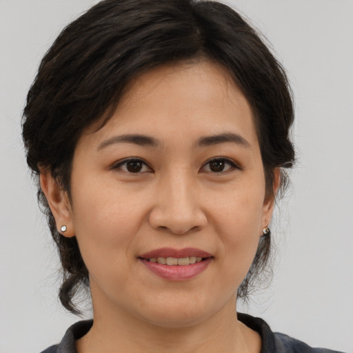 Joyful asian adult female with medium  brown hair and brown eyes
