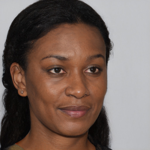 Joyful black young-adult female with long  brown hair and brown eyes