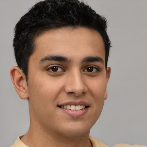 Joyful latino young-adult male with short  brown hair and brown eyes