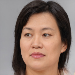 Joyful asian adult female with medium  brown hair and brown eyes