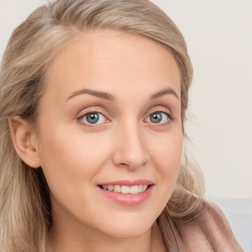 Joyful white young-adult female with long  brown hair and blue eyes