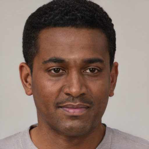 Joyful black young-adult male with short  black hair and brown eyes