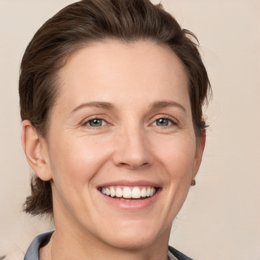 Joyful white young-adult female with short  brown hair and grey eyes