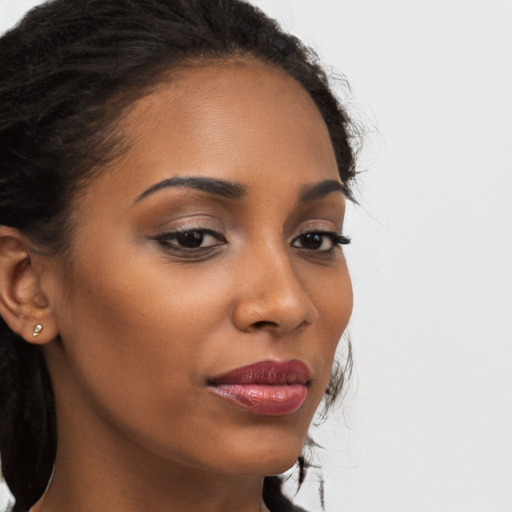 Joyful black young-adult female with long  brown hair and brown eyes