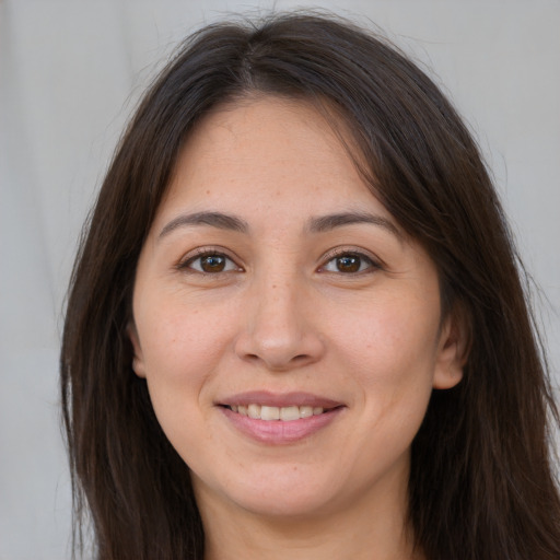 Joyful white young-adult female with long  brown hair and brown eyes