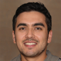 Joyful white young-adult male with short  black hair and brown eyes