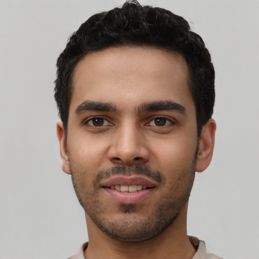 Joyful latino young-adult male with short  black hair and brown eyes