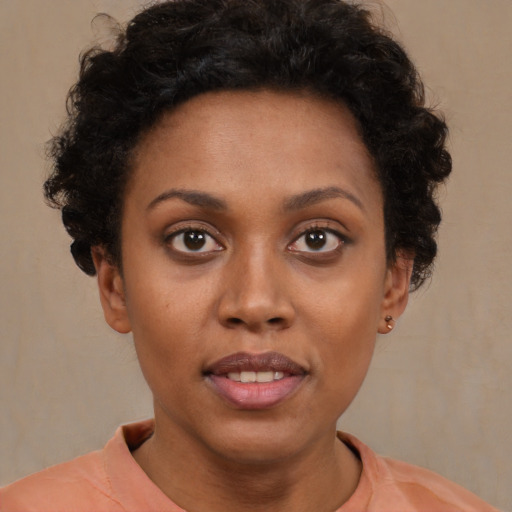 Joyful black young-adult female with short  brown hair and brown eyes