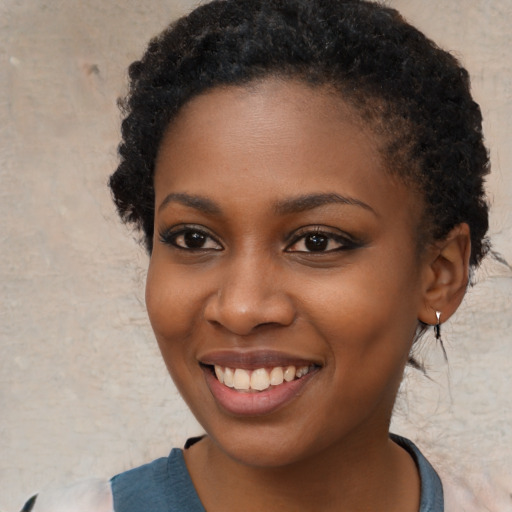 Joyful black young-adult female with short  black hair and brown eyes