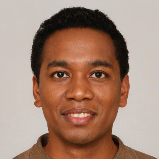 Joyful black young-adult male with short  black hair and brown eyes