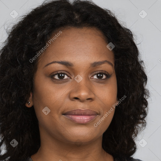 Joyful black young-adult female with long  brown hair and brown eyes