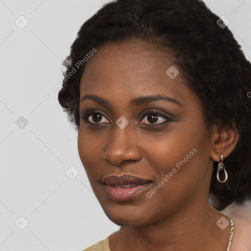 Joyful black young-adult female with long  black hair and brown eyes