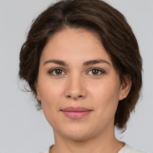 Joyful white young-adult female with medium  brown hair and brown eyes