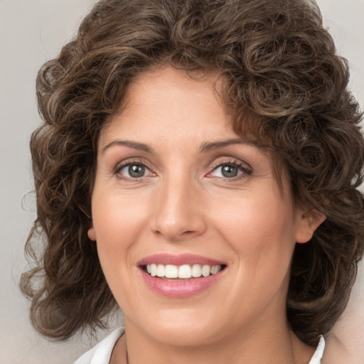 Joyful white young-adult female with medium  brown hair and green eyes