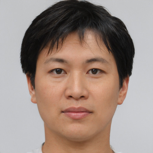 Joyful asian adult male with short  black hair and brown eyes