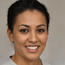 Joyful latino young-adult female with short  brown hair and brown eyes