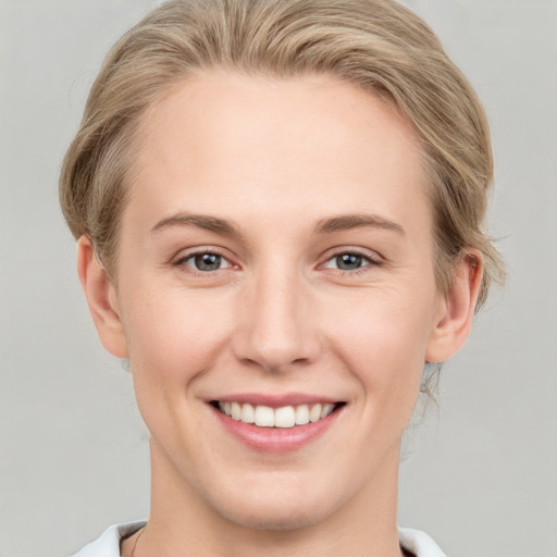 Joyful white young-adult female with medium  brown hair and grey eyes