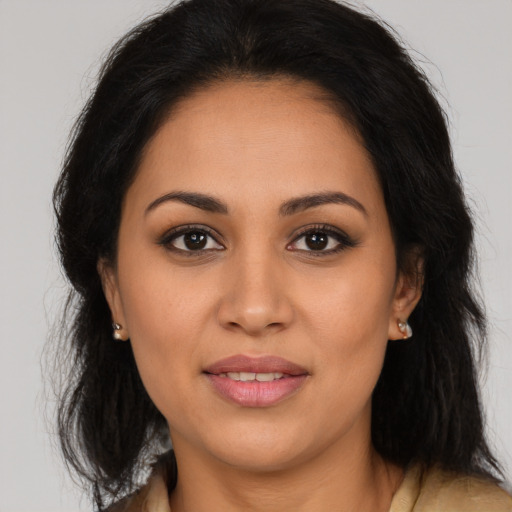 Joyful latino young-adult female with long  brown hair and brown eyes