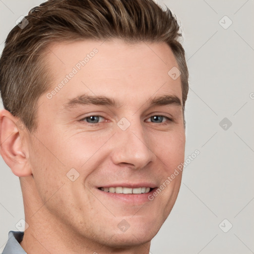 Joyful white young-adult male with short  brown hair and grey eyes