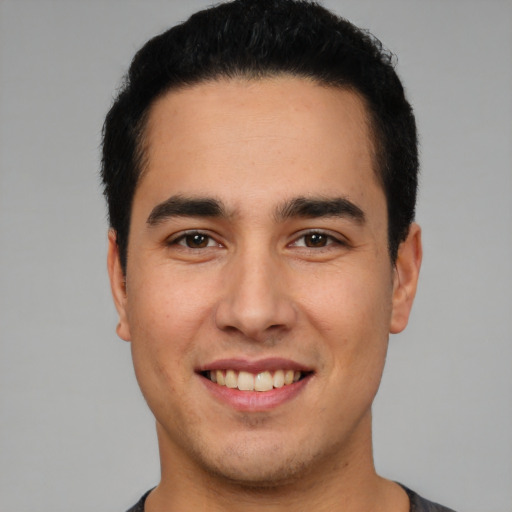 Joyful white young-adult male with short  black hair and brown eyes